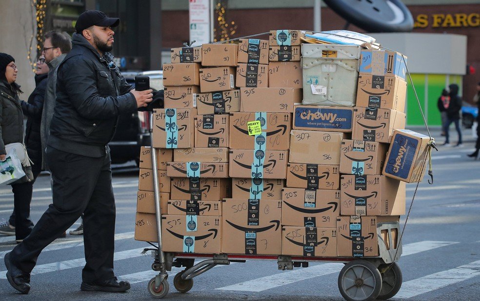 Homem transporta caixas da Amazon nas ruas de Nova York — Foto: Brendan McDermid/Reuters Homem transporta caixas da Amazon nas ruas de Nova York — Foto: Brendan McDermid/Reuters