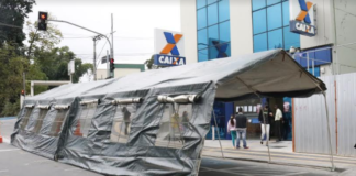 As tendas foram colocadas na rua da agência, onde já havia demarcação no asfalto para manter o distanciamento na fila.